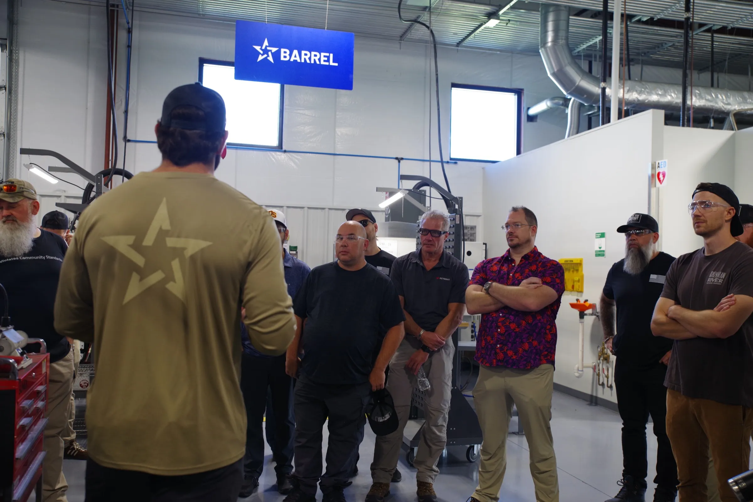 Group touring the Staccato factory floor beneath the barrel department sign